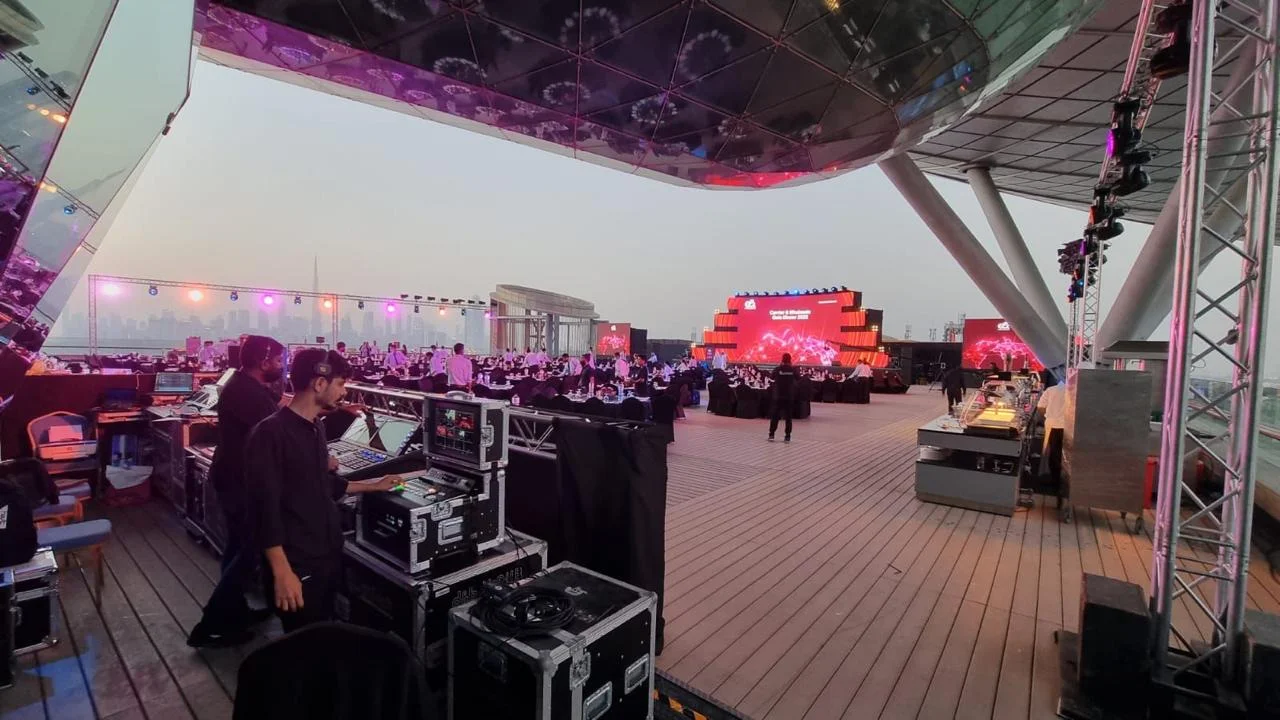Production team working at a control desk beside an outdoor event stage