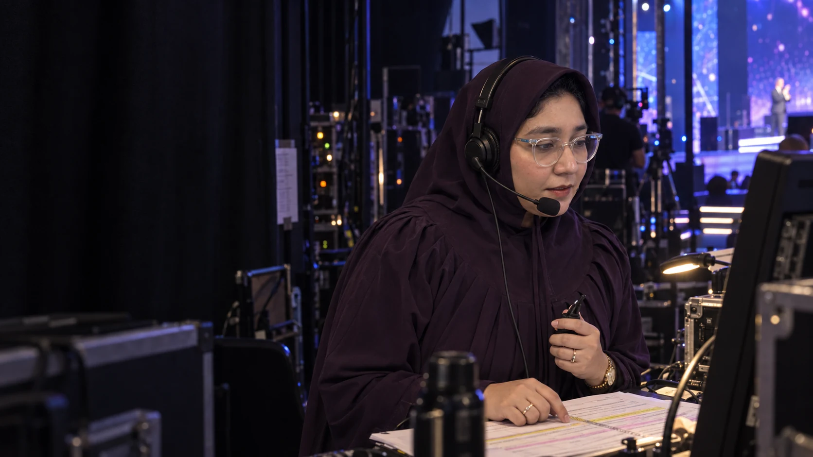 Editorial image of Zainab Murtaza wearing a production headset and reviewing show cues
